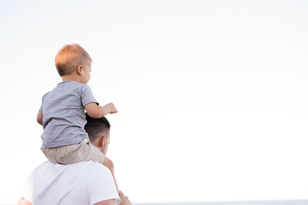 Man holding a baby on his back